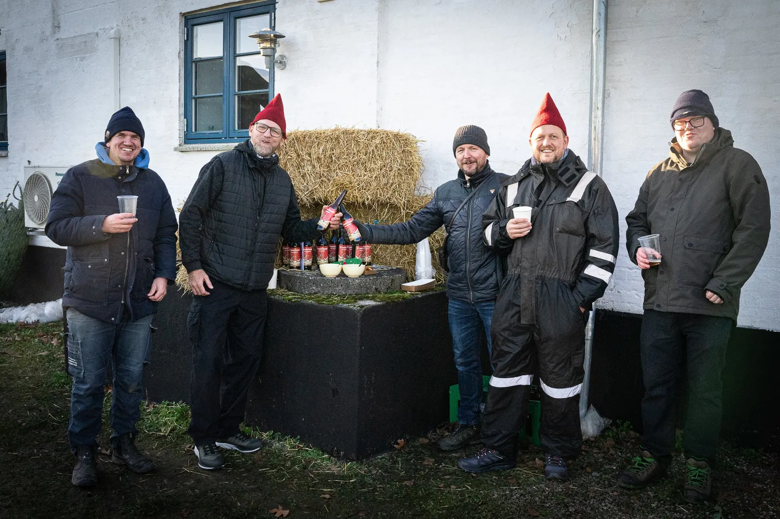 Beboere klædt ud som nisser ved halmballer på julemarkedet