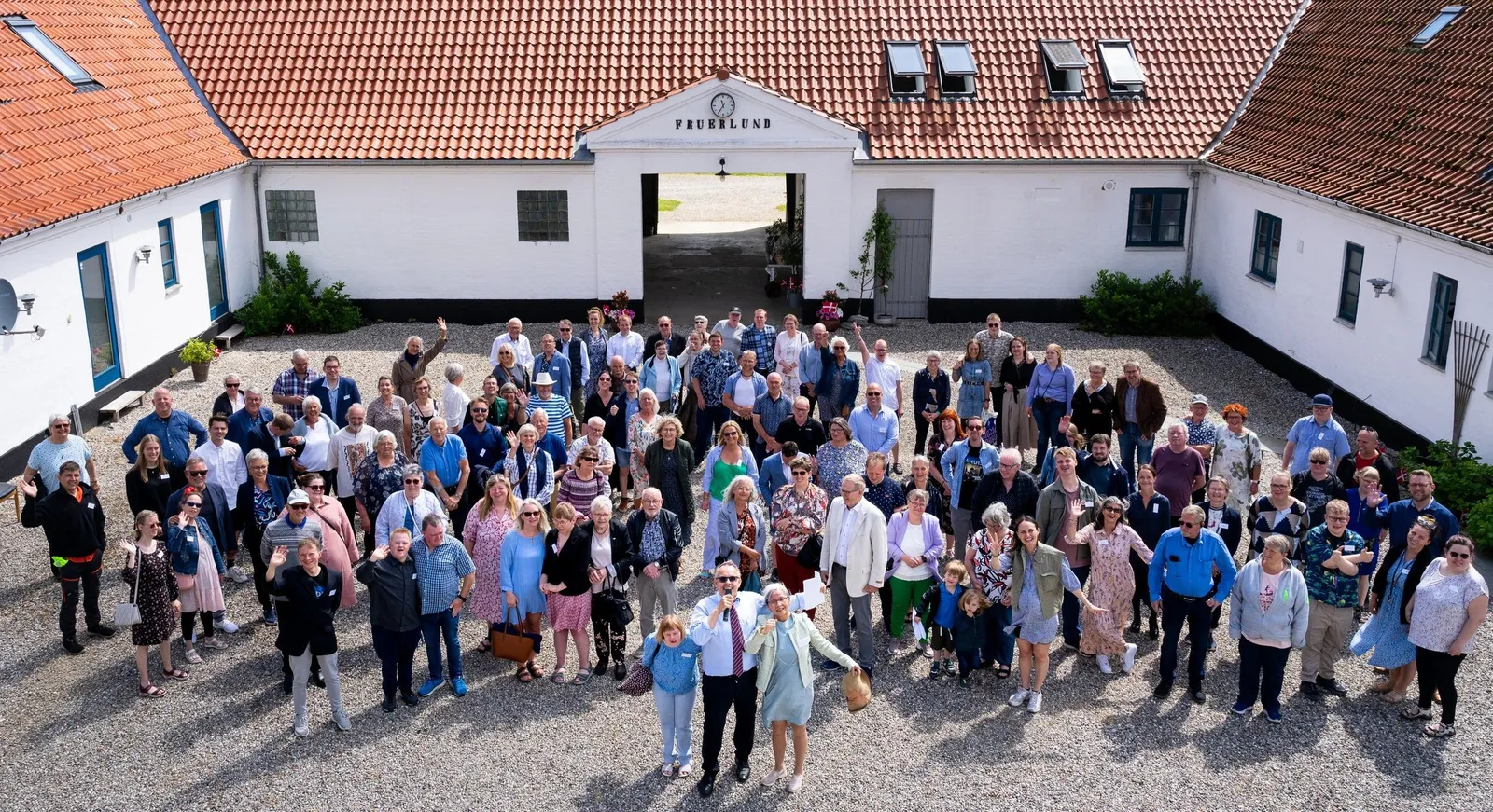 Beboere, familier og medarbejdere samlet i gårdsporten ved 20 års jubilæet