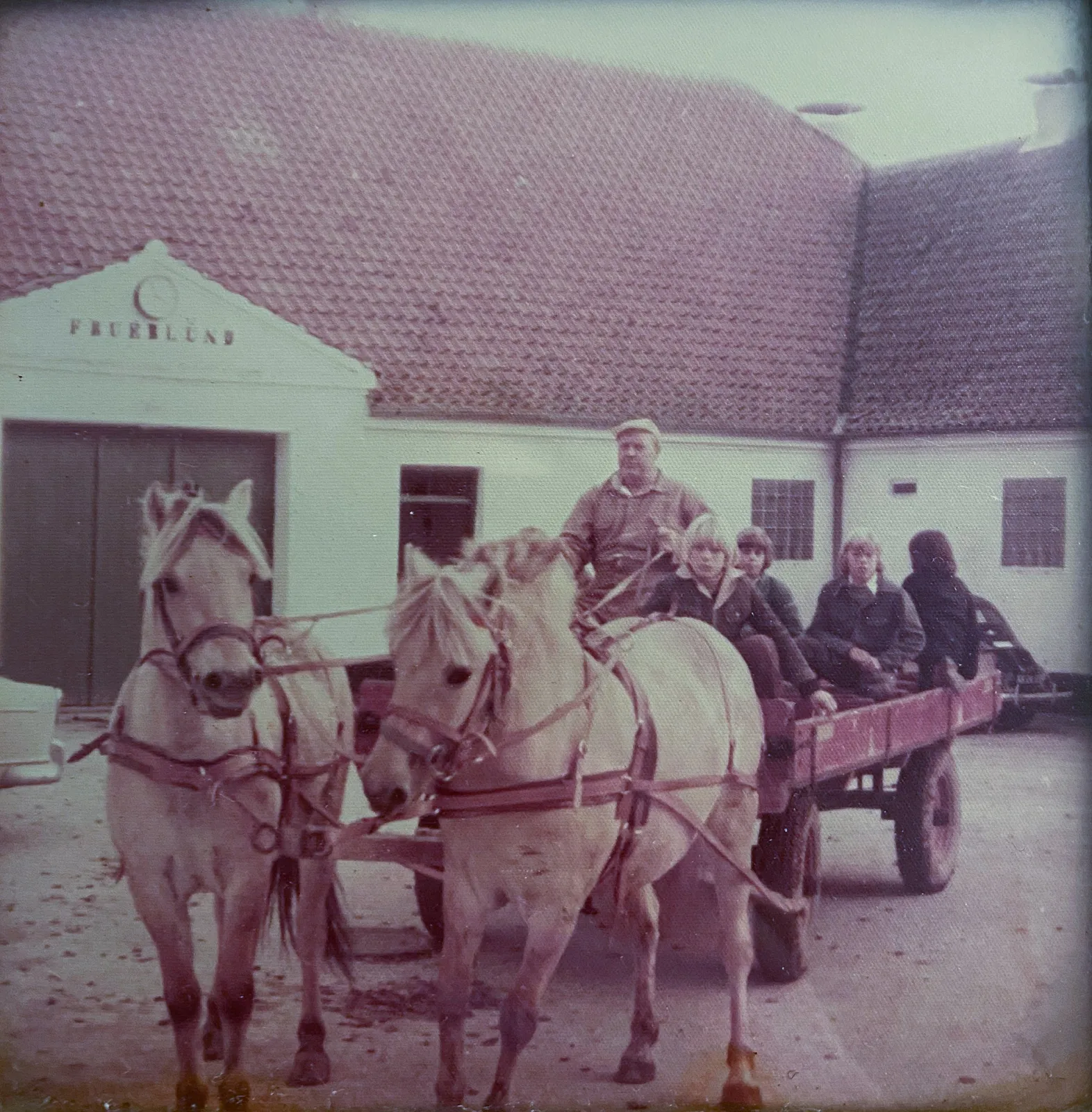 Historisk foto af hestevogn foran gårdens port